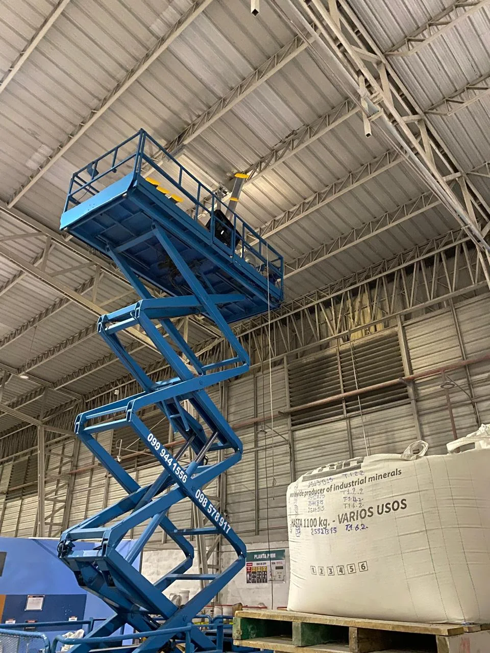 Trabajo en altura con plataforma elevadora en instalación industrial